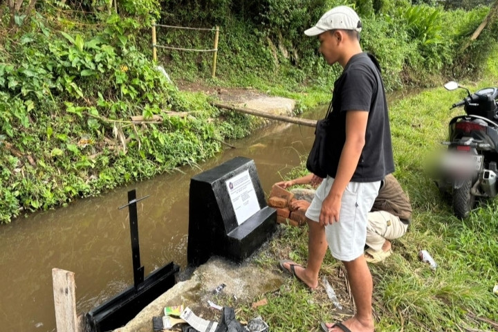 Mahasiswa KKN Universitas Muhammadiyah Malang (UMM) meninjau pintu irigasi yang baru dibangun di Desa Jambangan, Malang, sebagai solusi distribusi air sawah agar lebih merata dan mencegah potensi konflik antarpetani.